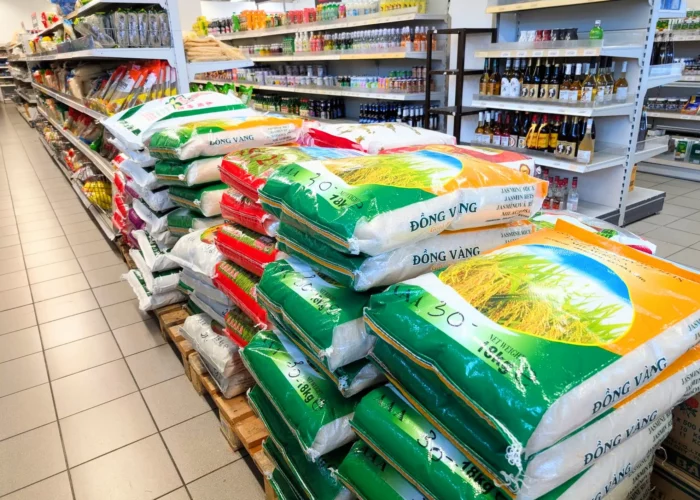 Sehr viele Reissäcke liegen gestapelt auf einer Palette.