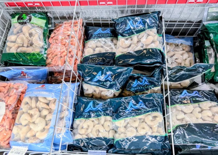 Mehrere Arten von Garnelen liegen verpackt in einem Tiefkühlregal.